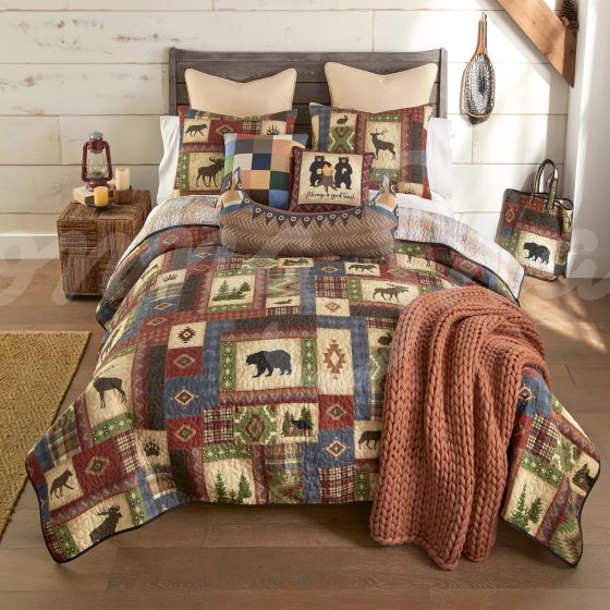 This quilt features a series of wildlife and cabin motifs.
