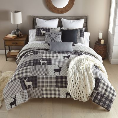 Ridge Point 3-Piece Comforter Set includes a black and white plaid comforter with deer motif, reversible to a grey and white pattern. Set includes 2 coordinating pillowcases. 