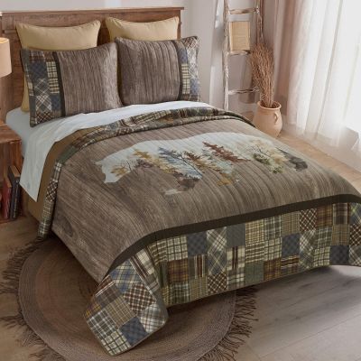 The quilt contains a woodgrain backdrop and plaid patchwork border.