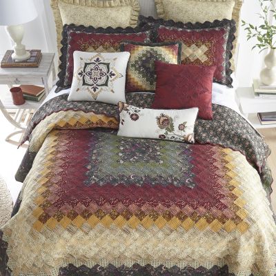 This quilt begins with golden pieces and radiates out to ginger, cinnamon, and deep sage.