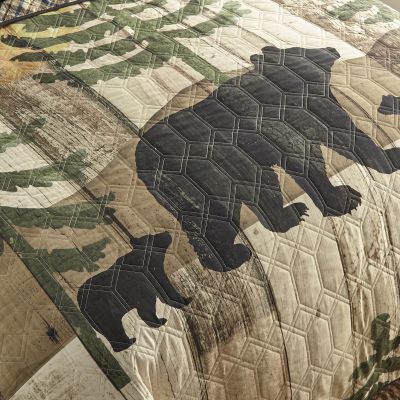 This quilt features a family of black bears in front of trees, mountains, and a sun.