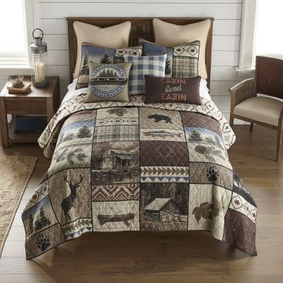 A close view of this quilt showcases the wildlife and cabin motif.