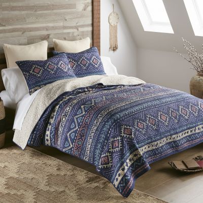 Southwestern style quilt with weathered finish in colors of navy, teal, coral and purple.