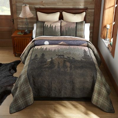 This quilt features a mountain scene with a mother bear and her two cubs while moonlight casts a shadow behind them. Colors include sand, fawn, shades of green, brown, navy and charcoal.