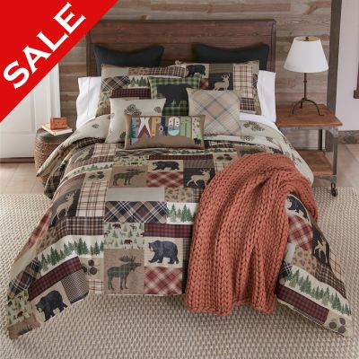 this comforter displays a variety of deer, moose, bear and pine motifs, arranged in a plaid patchwork.  