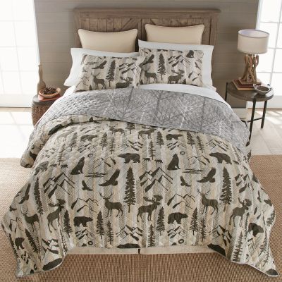 Forest Weave Quilt Set depicts images of nature including deer, bears, moose, and wolves with drawings of trees and mountains. Reverses to a printed pattern.