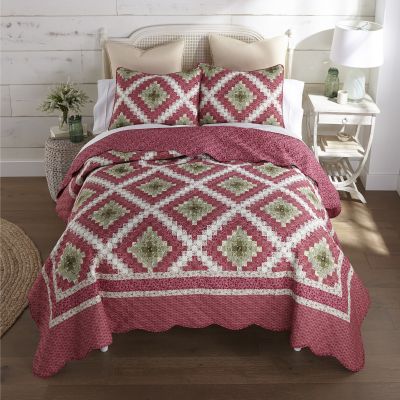 This quilt features small botanical and geometric prints are arranged in a classic Trip Around the World quilt pattern. Colors include watermelon, rose, deep mauve, olive green, tan, ivory, buttercream.  
