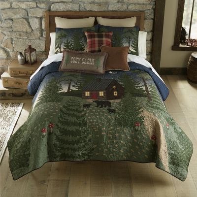 quilt design featuring a little cottage on a wooded hill in colors of green, caramel, blue, red, charcoal and wheat.